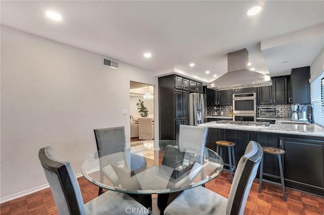 dining space with sink and dark parquet floors