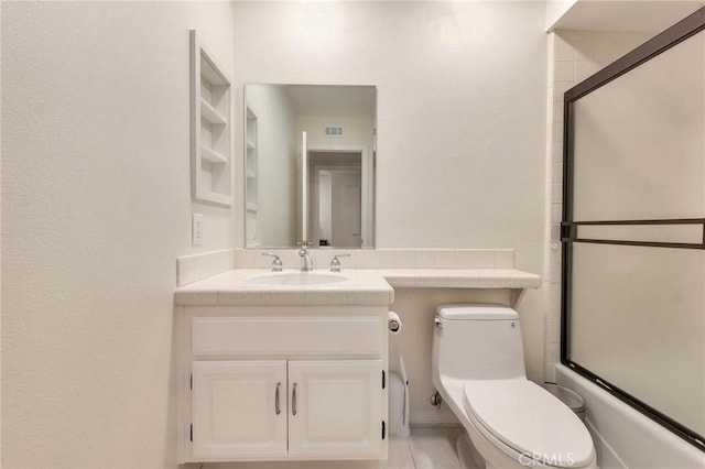 full bathroom featuring bath / shower combo with glass door, toilet, and vanity