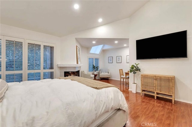 bedroom with hardwood / wood-style floors and vaulted ceiling with skylight