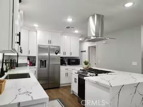 kitchen featuring stainless steel appliances, white cabinetry, and light stone countertops