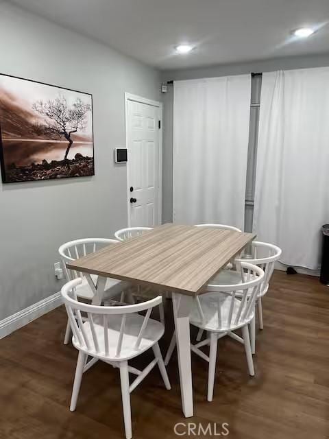 dining space with dark hardwood / wood-style flooring