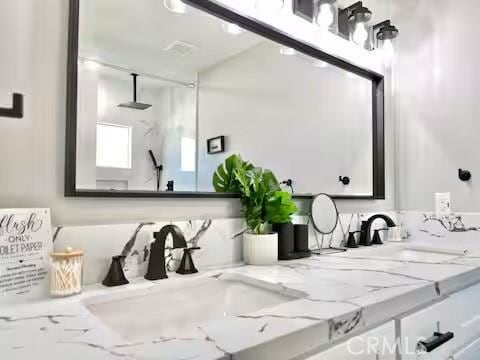 bathroom featuring walk in shower and vanity