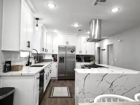 kitchen with sink, white cabinets, stainless steel fridge with ice dispenser, light stone countertops, and island range hood