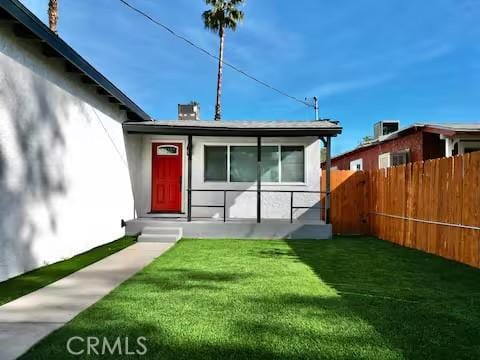 exterior space with a front lawn and central AC unit