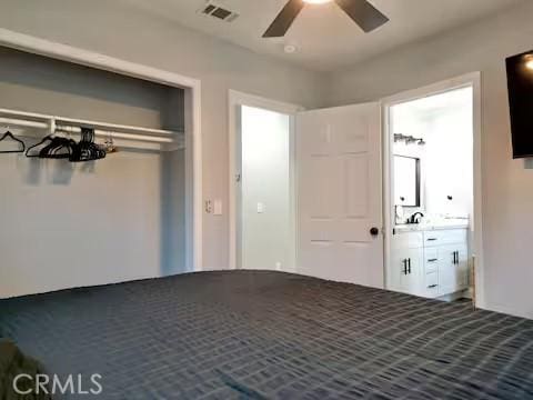 unfurnished bedroom featuring a closet, ceiling fan, and connected bathroom