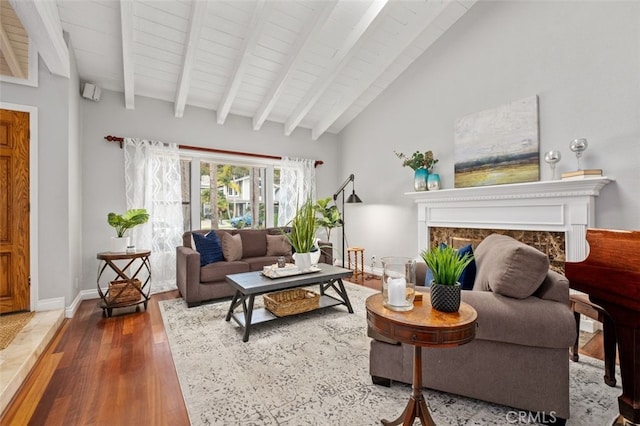 living room featuring wood ceiling, a high end fireplace, wood-type flooring, and vaulted ceiling with beams