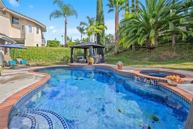 view of pool with a gazebo and an in ground hot tub