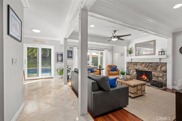 living room featuring crown molding, ceiling fan, and a fireplace