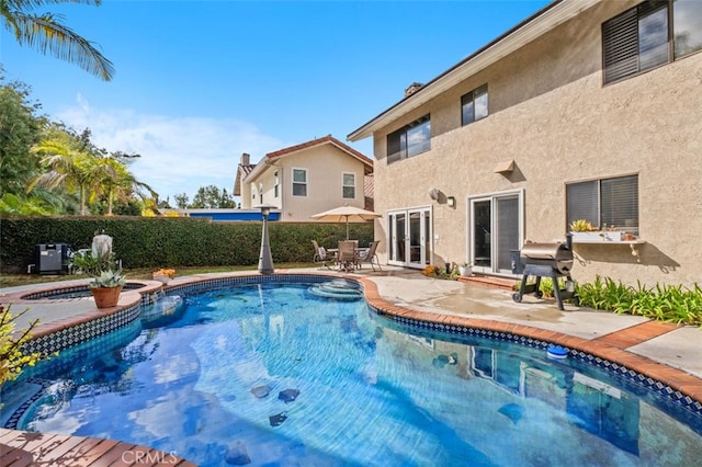 view of pool with a grill, a patio area, and an in ground hot tub