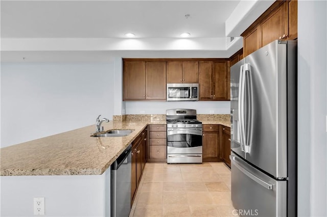 kitchen with light stone countertops, appliances with stainless steel finishes, sink, kitchen peninsula, and light tile patterned floors