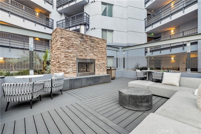 deck featuring an outdoor living space with a fireplace