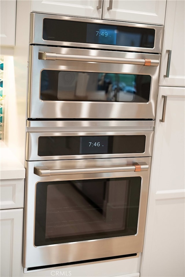 details with white cabinetry and stainless steel double oven