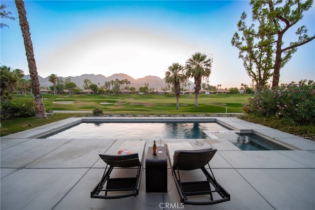 view of pool featuring a mountain view, a patio area, a jacuzzi, and a lawn