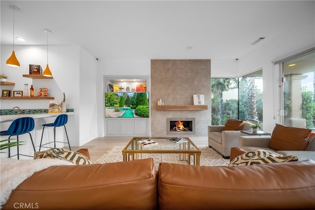 living room with light hardwood / wood-style floors and a large fireplace