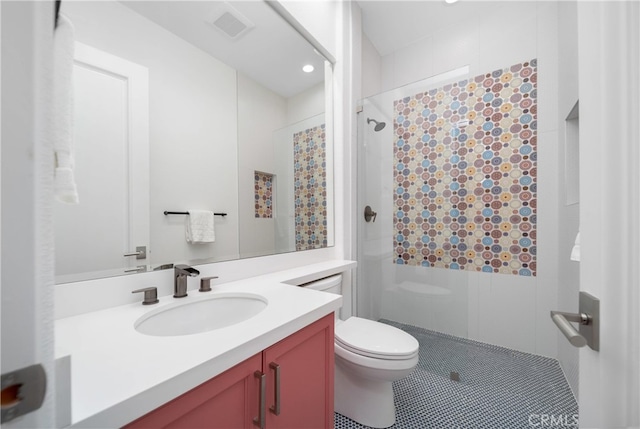 bathroom featuring a tile shower, toilet, and vanity