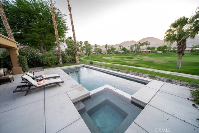 view of pool with an in ground hot tub, a lawn, a mountain view, and a patio