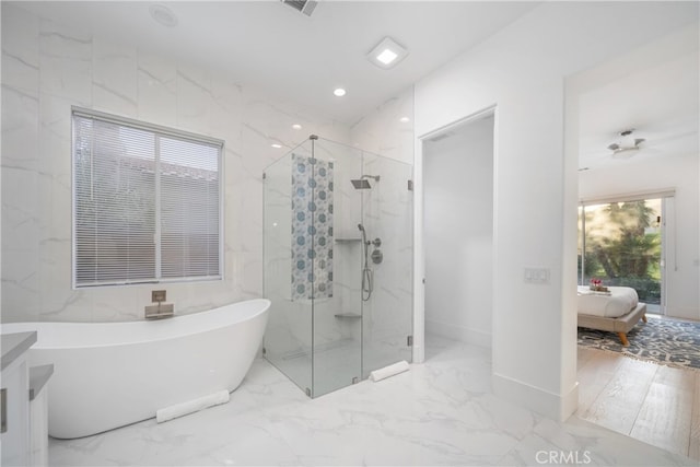 bathroom with vanity and shower with separate bathtub