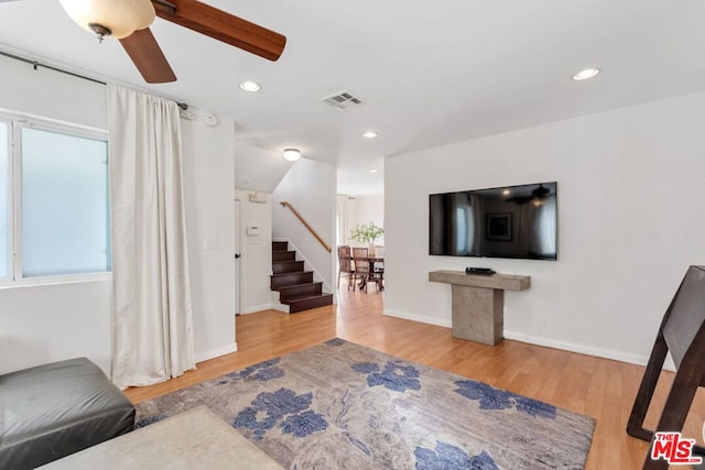 living room with ceiling fan and wood-type flooring