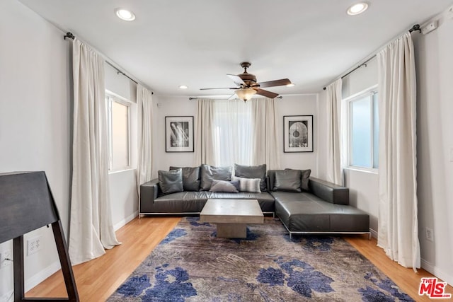 living room featuring hardwood / wood-style floors and ceiling fan