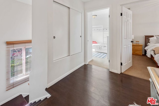 hall with dark colored carpet