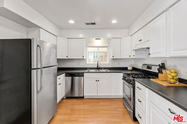 kitchen featuring sink, white cabinets, appliances with stainless steel finishes, and light wood-type flooring