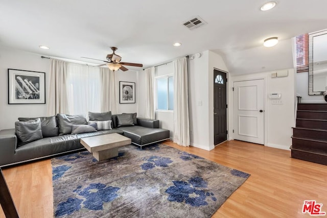 living room featuring ceiling fan, vaulted ceiling, and wood-type flooring