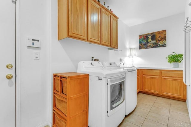 laundry room with cabinets, washing machine and dryer, and light tile patterned floors