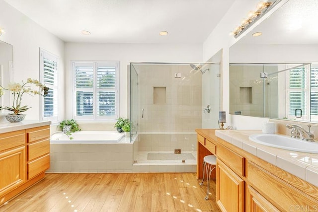 bathroom with vanity, hardwood / wood-style flooring, and separate shower and tub