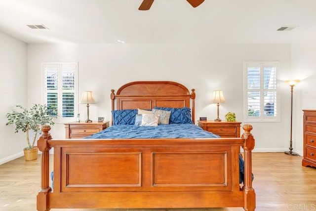 bedroom with multiple windows, ceiling fan, and light wood-type flooring