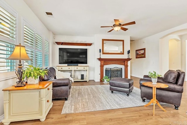 living room with light hardwood / wood-style flooring and ceiling fan