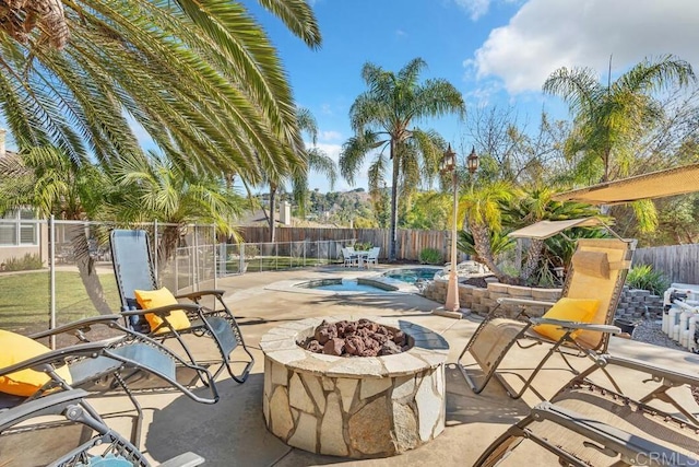 view of patio with a fenced in pool and a fire pit