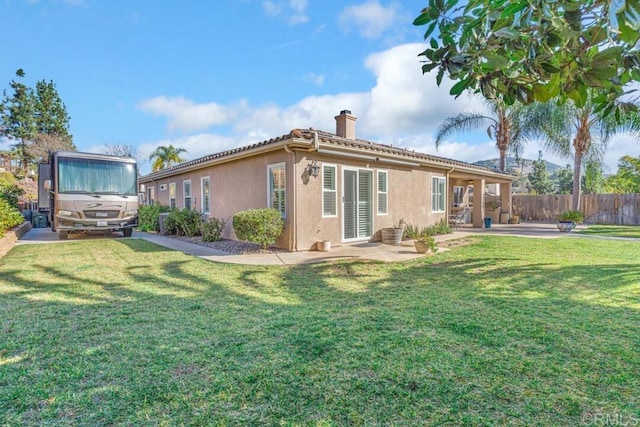 back of property featuring a patio and a lawn