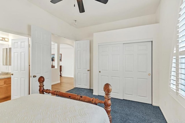 carpeted bedroom with ceiling fan, ensuite bathroom, and a closet