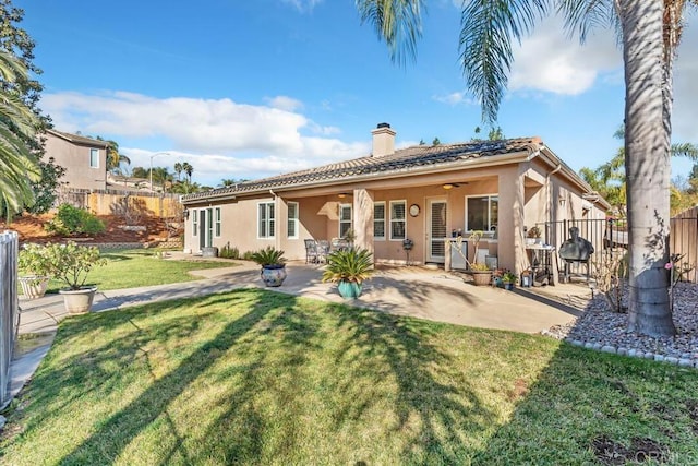 back of property with a patio, ceiling fan, and a lawn