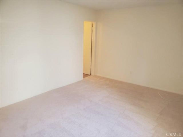 spare room featuring light colored carpet