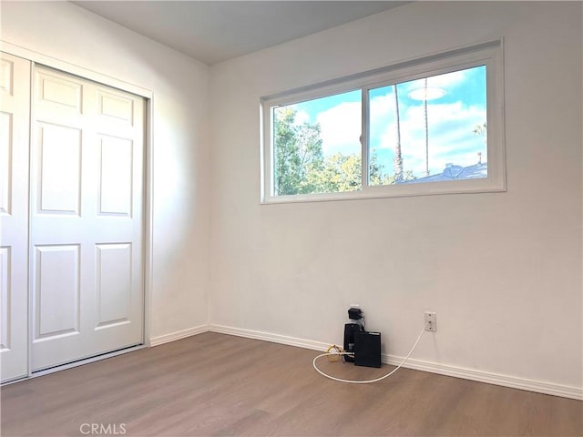 unfurnished bedroom with wood-type flooring and a closet