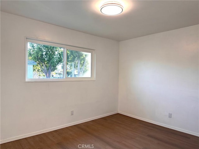 empty room with dark hardwood / wood-style flooring