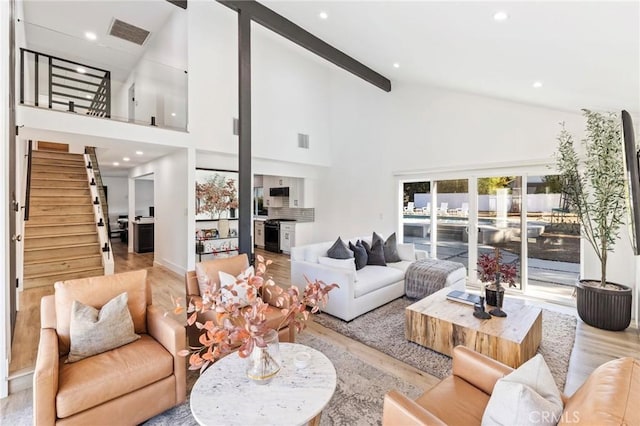 living room featuring light wood-type flooring, beam ceiling, and high vaulted ceiling