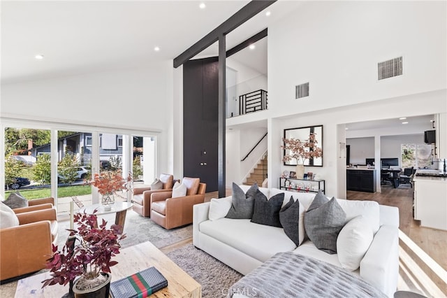 living room with light hardwood / wood-style flooring and high vaulted ceiling