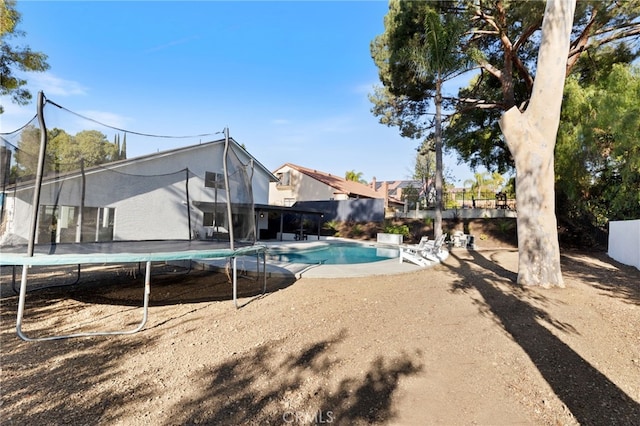 view of pool featuring a patio and a trampoline