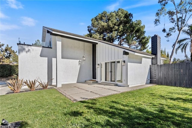 rear view of property with a lawn and a patio