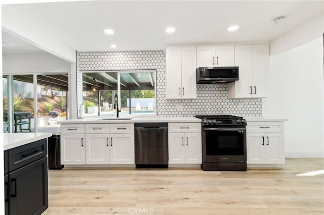 kitchen featuring sink, white cabinetry, black dishwasher, and gas stove