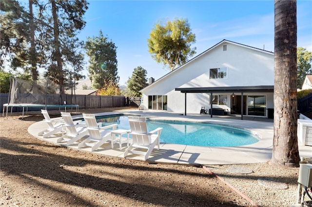 view of pool with a patio area and a trampoline