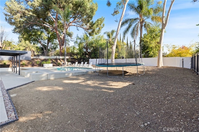 view of swimming pool featuring a patio and a trampoline