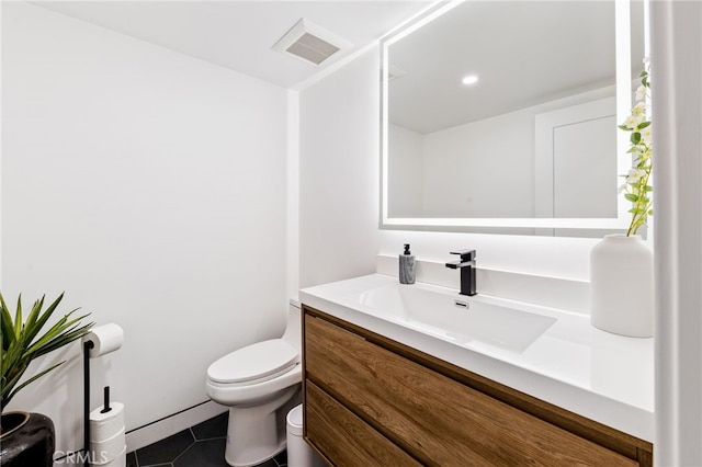 bathroom featuring vanity, toilet, and tile patterned flooring