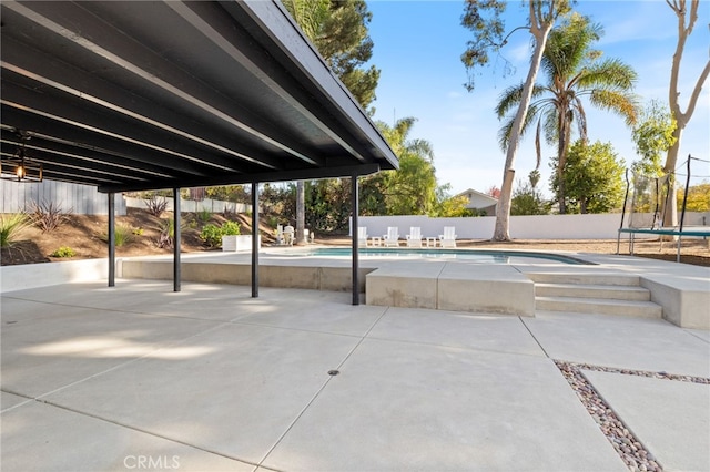 view of swimming pool with a patio and a trampoline