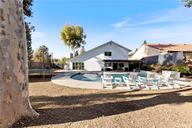 view of swimming pool with a patio and a trampoline