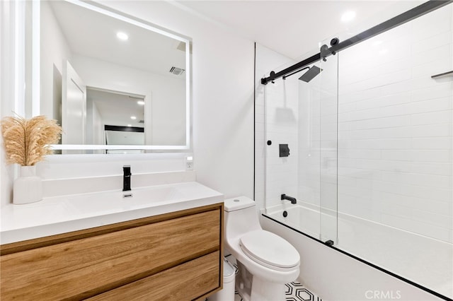 full bathroom featuring combined bath / shower with glass door, vanity, and toilet