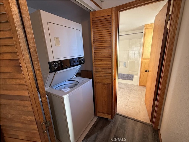 washroom featuring stacked washer and clothes dryer and dark wood-type flooring