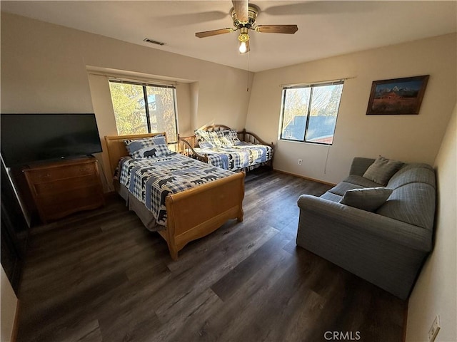 bedroom with dark wood-type flooring, multiple windows, and ceiling fan